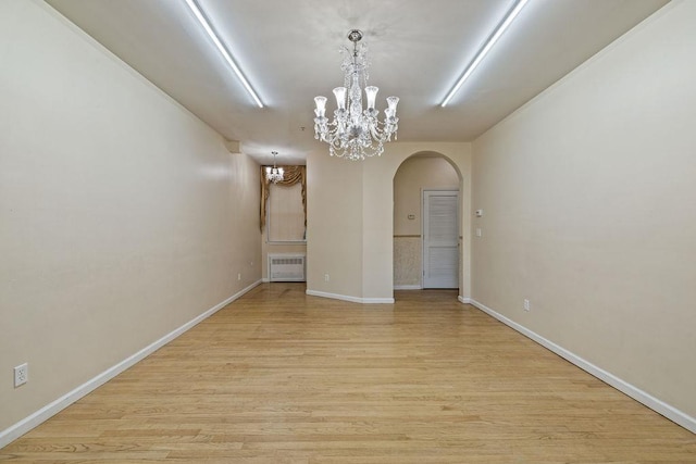 unfurnished dining area with light hardwood / wood-style floors and a notable chandelier