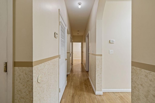 hall featuring tile walls and light hardwood / wood-style flooring