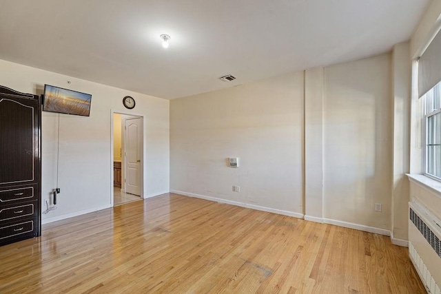 unfurnished bedroom with light wood-type flooring and radiator