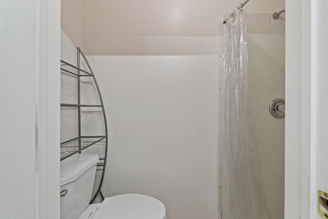 bathroom with toilet and a shower with shower curtain