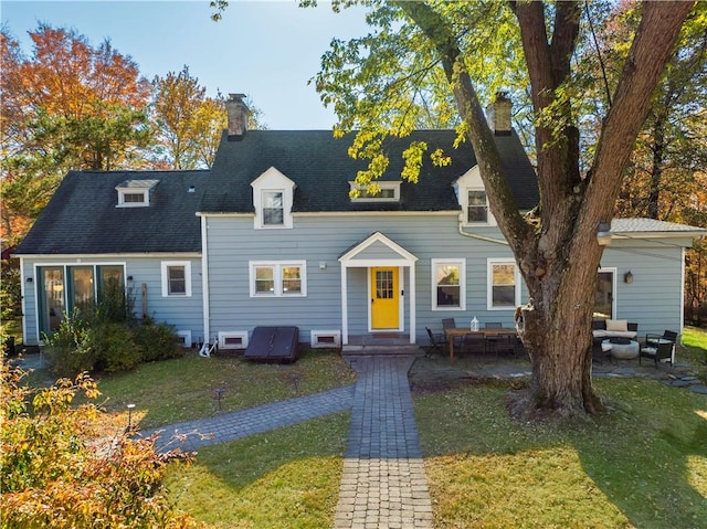 new england style home featuring a patio area and a front lawn