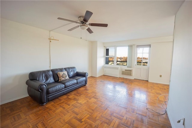 living room featuring radiator heating unit, dark parquet floors, a wall mounted AC, and ceiling fan