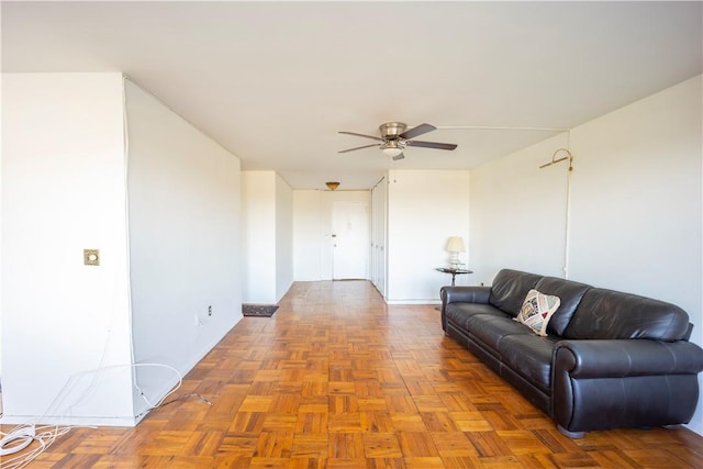 living room featuring ceiling fan and parquet flooring