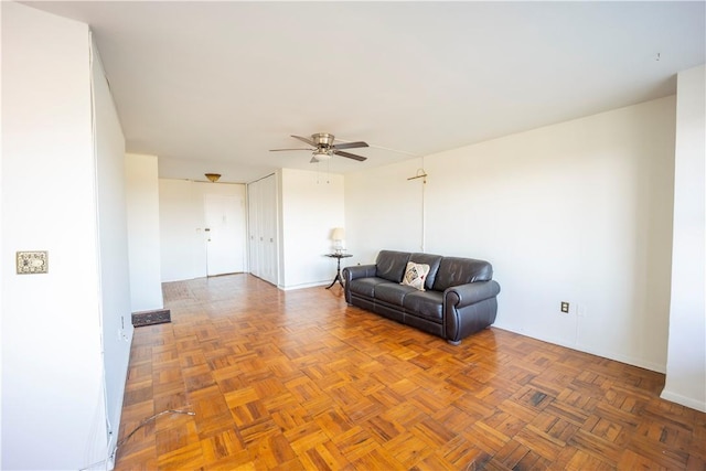 unfurnished living room featuring ceiling fan and parquet floors