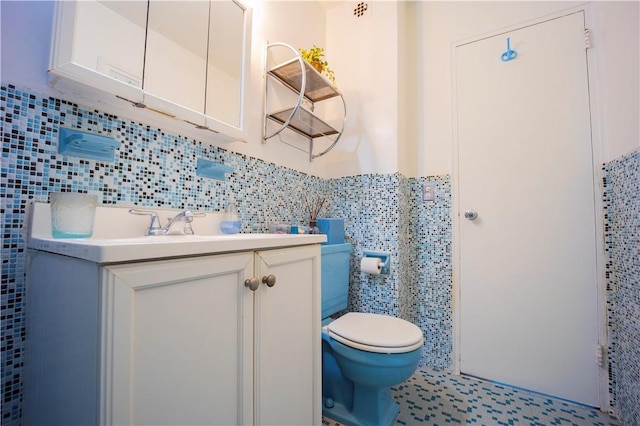 bathroom featuring vanity, tile walls, and toilet