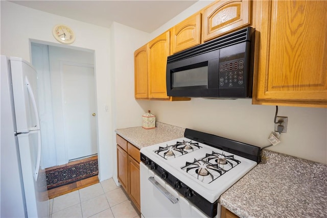 kitchen with light tile patterned flooring and white appliances