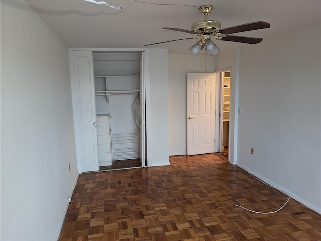 unfurnished bedroom with ceiling fan, a closet, and dark parquet floors