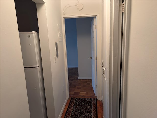 hallway featuring dark parquet flooring