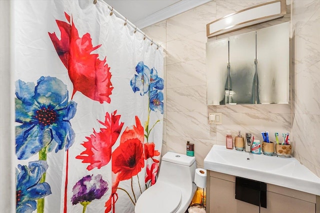 bathroom with vanity, toilet, tile walls, and ornamental molding