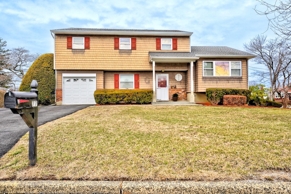 view of front of house featuring a front lawn and a garage