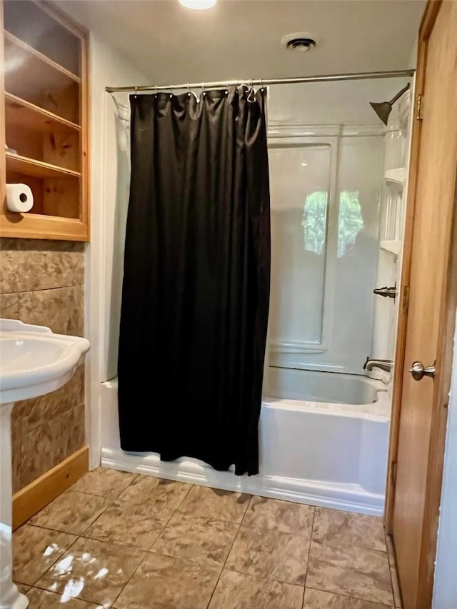 bathroom featuring tile patterned floors and shower / bath combo with shower curtain