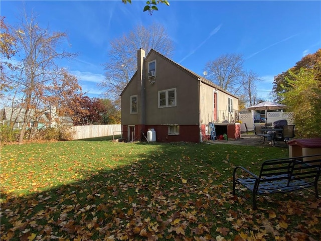 rear view of property featuring a yard and a patio area