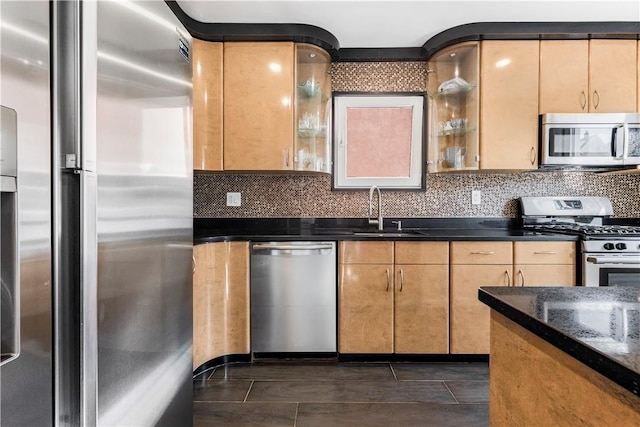 kitchen featuring light brown cabinetry, sink, dark stone counters, and appliances with stainless steel finishes