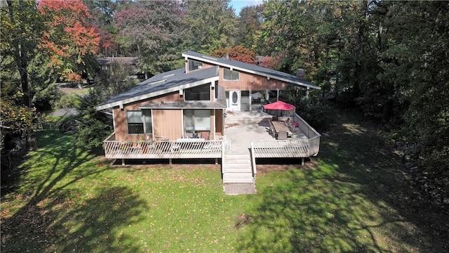 rear view of property with a yard and a deck