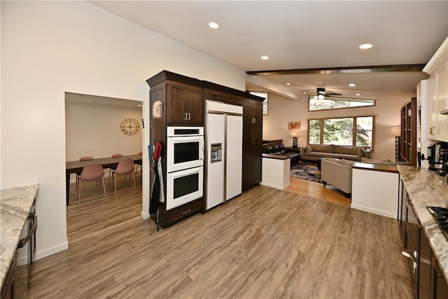 kitchen featuring white appliances, lofted ceiling with beams, ceiling fan, light wood-type flooring, and dark brown cabinets