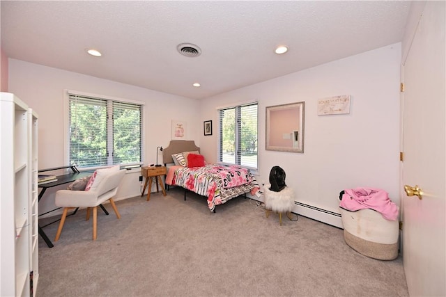 bedroom with carpet, baseboard heating, and multiple windows