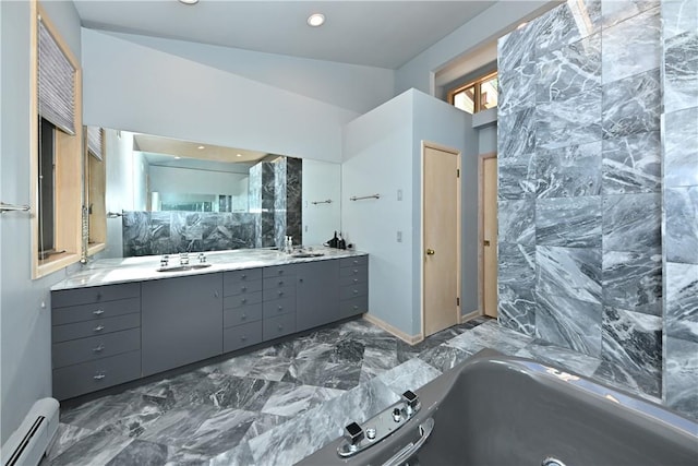 bathroom with baseboard heating, a bathing tub, vanity, and vaulted ceiling