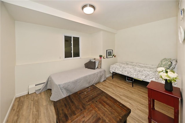 bedroom with wood-type flooring and a baseboard radiator