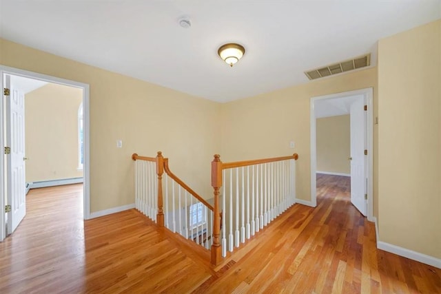 hall with light wood-type flooring and a baseboard radiator