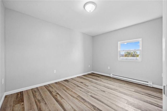 unfurnished room featuring a baseboard radiator and light hardwood / wood-style flooring