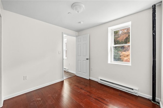 spare room with dark hardwood / wood-style flooring and baseboard heating