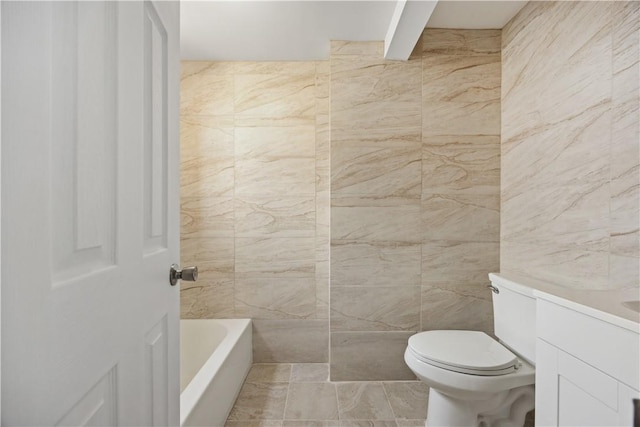 bathroom featuring vanity, toilet, tile walls, and a tub