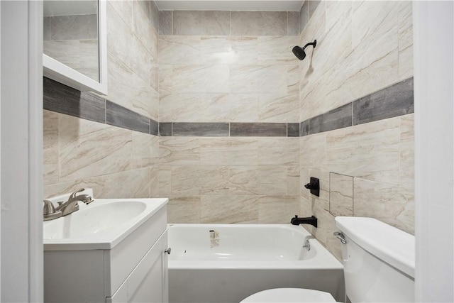 full bathroom featuring vanity, toilet, tile walls, and tiled shower / bath