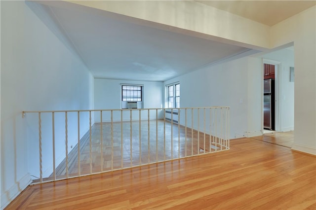 empty room featuring cooling unit and wood-type flooring