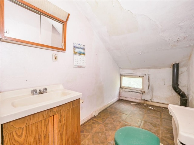 bathroom with parquet floors, vanity, lofted ceiling, and toilet