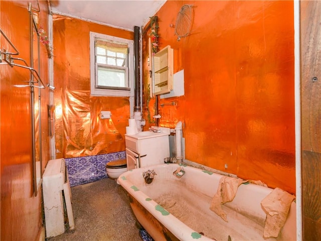 bathroom featuring sink, radiator heating unit, a bath, and toilet