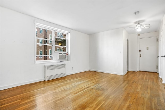 interior space with ceiling fan, light hardwood / wood-style floors, and radiator