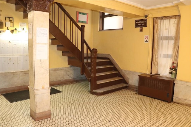 staircase featuring a mail area and ornamental molding