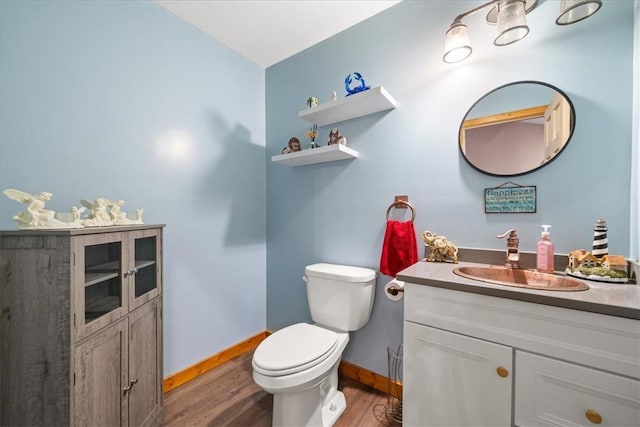 bathroom with vanity, wood finished floors, toilet, and baseboards