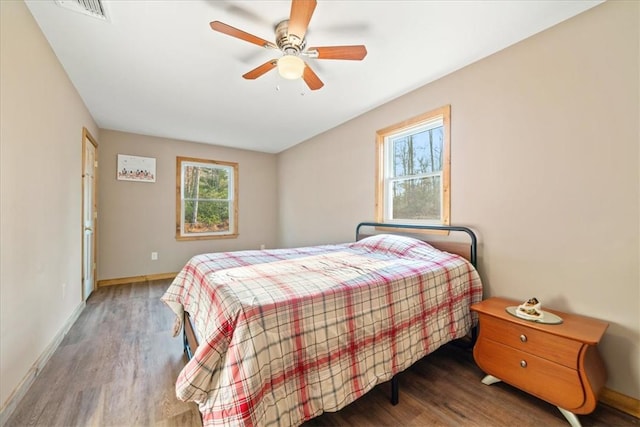 bedroom featuring visible vents, ceiling fan, baseboards, and wood finished floors