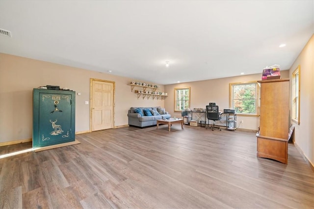 unfurnished living room featuring baseboards, visible vents, wood finished floors, and recessed lighting