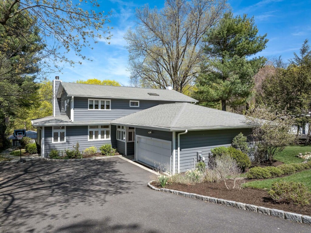 107 Judson Ave, Dobbs Ferry, NY 10522 - view of front facade featuring an attached garage, a chimney, and aphalt driveway