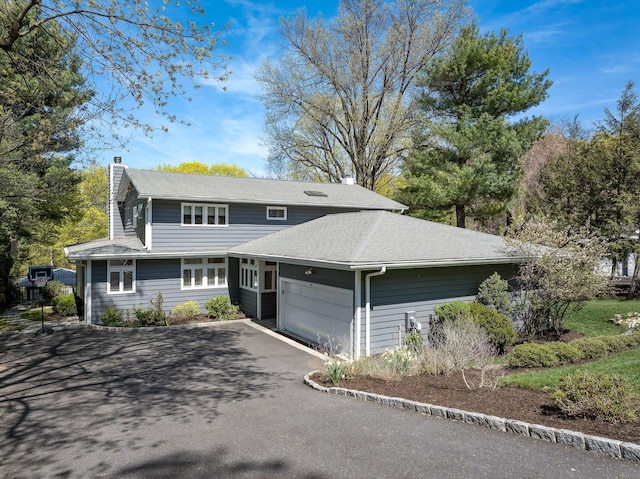 107 Judson Ave, Dobbs Ferry, NY 10522 - view of front facade featuring an attached garage, a chimney, and aphalt driveway