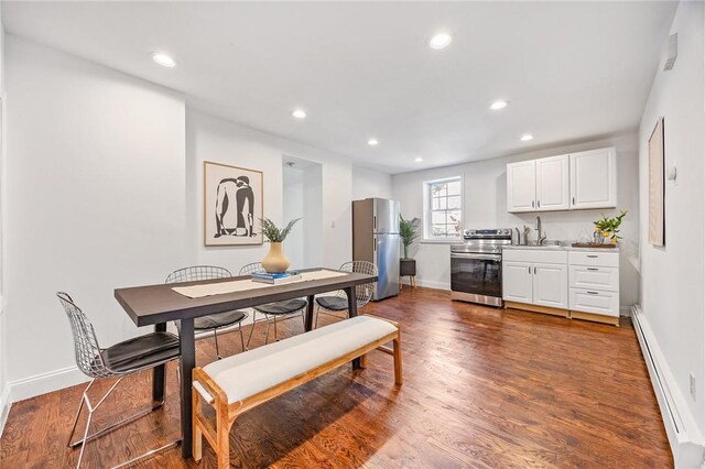 dining space with hardwood / wood-style floors, sink, and a baseboard radiator