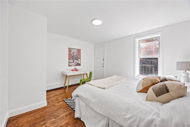 bedroom with hardwood / wood-style floors and a baseboard radiator