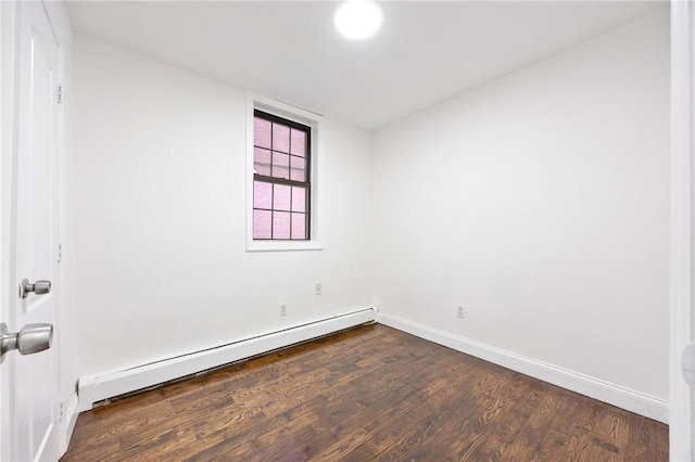 spare room featuring dark hardwood / wood-style floors and a baseboard radiator