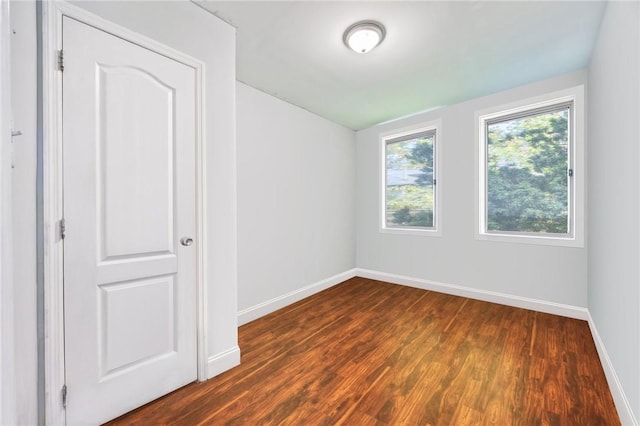 unfurnished room with dark wood-type flooring