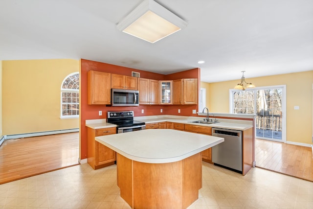 kitchen with pendant lighting, a kitchen island, stainless steel appliances, and sink