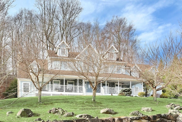 farmhouse inspired home featuring a porch and a front lawn