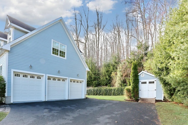 view of property exterior featuring a garage and a storage shed