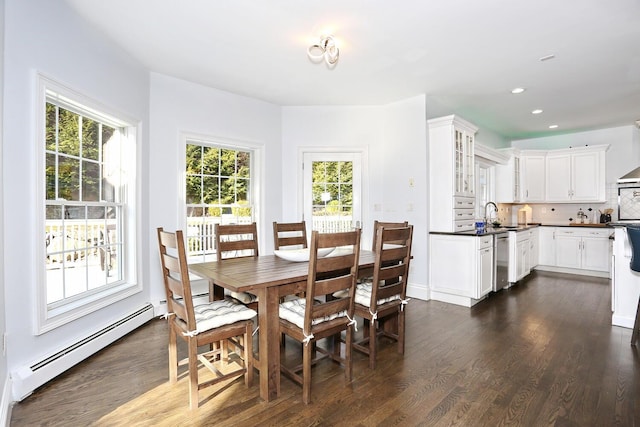 dining room featuring sink, a wealth of natural light, a baseboard heating unit, and dark hardwood / wood-style floors