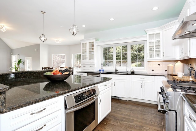 kitchen featuring stainless steel appliances, white cabinetry, and wall chimney exhaust hood