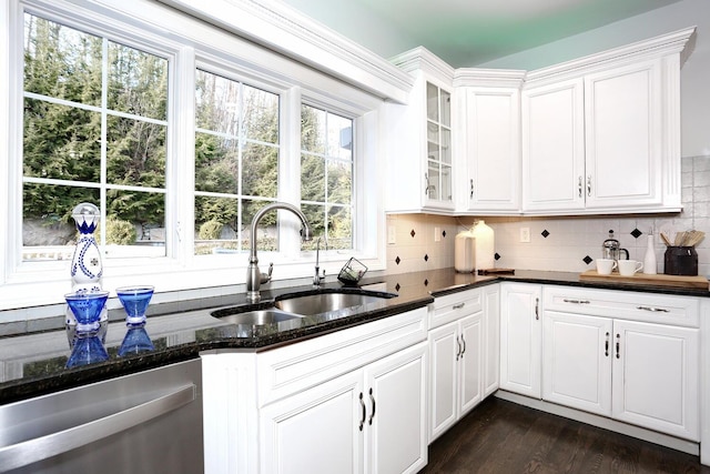 kitchen featuring sink, stainless steel dishwasher, white cabinetry, and dark stone countertops