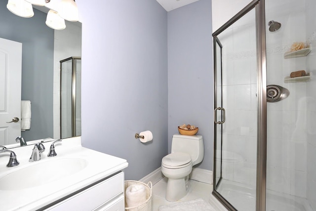 bathroom featuring tile patterned floors, a shower with door, toilet, and vanity