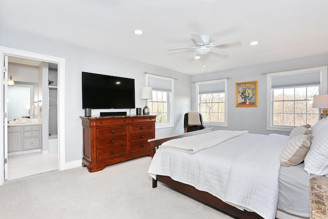 bedroom with light carpet, ensuite bath, and ceiling fan