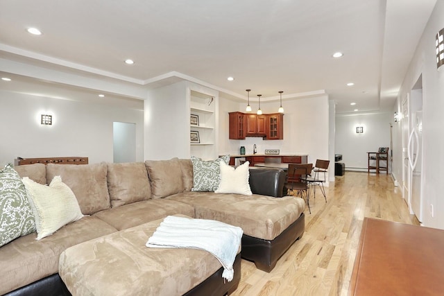 living room featuring built in features, light hardwood / wood-style flooring, and ornamental molding